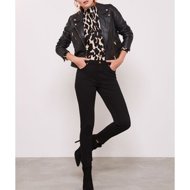 Model wearing Mint Velvet Maryland Skinny Jeans in black, styled with a black leather jacket, animal print top and black ankle boots