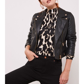 Model wearing Mint Velvet Maryland Skinny Jeans in black, styled with a black leather biker jacket and animal print top