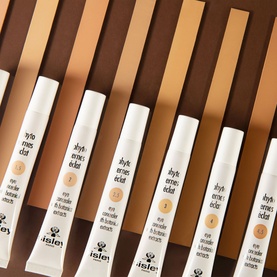 Sisley Phyto-Cernes Eclat Tinted Eye Concealer 15ml shown in multiple shades arranged in a fan layout on warm-toned background