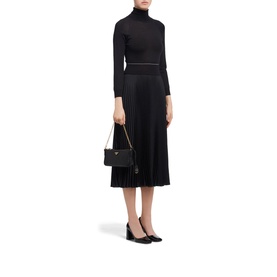 Model carrying Prada Accessories Re-Edition 2000 Shoulder Bag in black Saffiano leather with gold chain strap