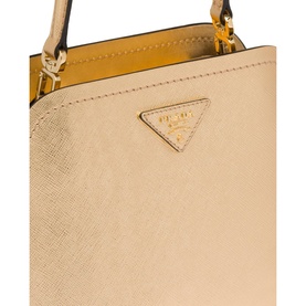 Prada Accessories Matin&eacute;e Saffiano Leather Micro Bag in grey, close-up of gold-tone triangular logo plaque on structured saffiano leather body