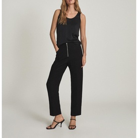 Model wearing Reiss Riley Silk Front Vest Top in black with scoop neckline, styled with matching black trousers and heeled mules
