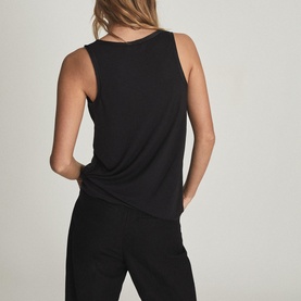 Model wearing Reiss Riley Silk Front Vest Top in black, sleeveless relaxed fit, styled with black wide-leg trousers. Rear view