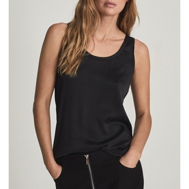 Model wearing Reiss Riley Silk Front Vest Top in black, sleeveless with scoop neckline, styled with black zip-detail trousers