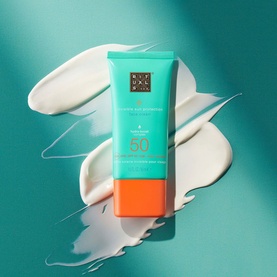 Rituals Ritual Sun Care Karma SPF50 tube in teal and orange, shown with white cream swatch on teal background