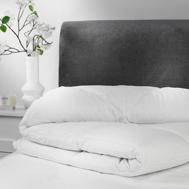 Snuggledown Hungarian Goose Down Natural Retreat Collection Duvet 13.5 Tog in white, folded on a bed with grey upholstered headboard