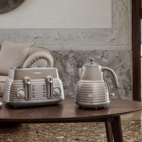 Delonghi Scolpito Kettle in beige with ribbed design, styled alongside matching beige toaster on a wooden table