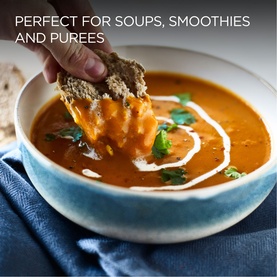 Blue ceramic bowl filled with smooth orange soup, cream swirl and herbs, with bread being dipped in. Text reads Perfect for Soups
