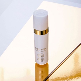 Sisley Sisle&yuml;a L'Int&eacute;gral Anti-&Acirc;ge Firming Concentrated Serum in white and gold pump bottle on reflective gold surface