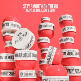 Sol De Janeiro Bom Dia Bright Body Cream multiple stacked white and red jars arranged in a pyramid display on red background