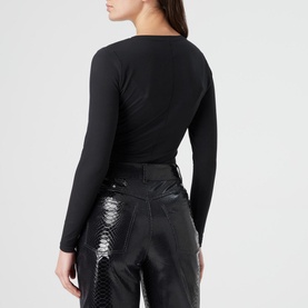 Model wearing Spanx Suit Yourself V-Neck Bodysuit in black, long sleeves, shot from behind, styled with black snake-print trousers