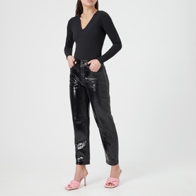 Model wearing Spanx Suit Yourself V-Neck Bodysuit in black with black patent trousers and pink heeled mules