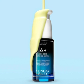 Sunday Riley A+ High-Dose Retinoid Serum bottle with yellow serum liquid spilling over it against a light blue background.