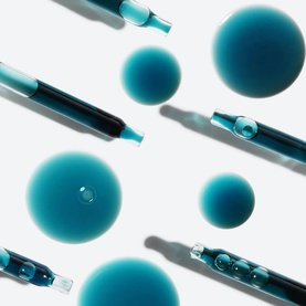 Sunday Riley Luna Sleeping Night Oil teal-blue droppers and spherical oil droplets arranged on white background
