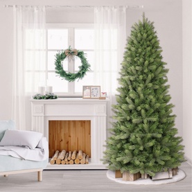 Puleo Slim Kensington Fir Tree 7.5ft, slim green artificial Christmas tree styled in a bright living room with fireplace and wreath