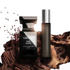 Tom Ford Oud Wood Eau de Parfum 50ml bottle and travel spray displayed with wood and spice accents