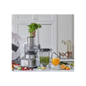 Sage The 3X Bluicer Pro Blender in brushed steel, shown in use on kitchen counter with fresh greens, citrus fruits and green juice