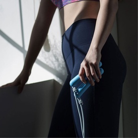 Model with Tangram SmartRope Rookie Blue jump rope handle in blue, styled with navy blue leggings