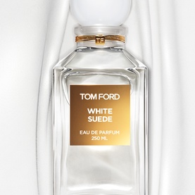 Tom Ford White Suede Eau de Parfum 250ml clear glass decanter bottle with gold label and stopper, draped white fabric background.