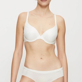 Model wearing Triumph Body Make-Up Wired Bra in white, push-up style with padded cups and adjustable straps, paired with matching white briefs