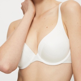 Model wearing Triumph Body Make-Up Wired Bra in white, a padded push-up style with smooth cups and adjustable straps