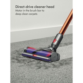 Dyson Home V10 Cyclone Absolute Cordless Stick Vacuum Cleaner direct-drive cleaner head in copper, shown cleaning carpet