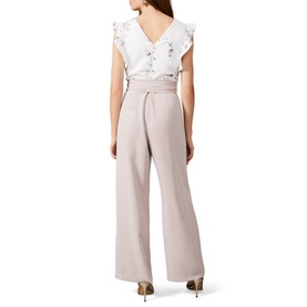 Model wearing Phase Eight Victoriana Printed Jumpsuit in cream, showing rear view with ruffle sleeves, floral print top and wide-leg trousers