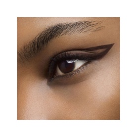 Model with Yves Saint Laurent Crushliner Waterproof Liner in deep brown, shown as a precise winged eyeliner look on deep skin tone