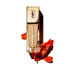 Yves Saint Laurent Touche &Eacute;clat Le Teint Natural Glow Foundation SPF22 25ml in glass bottle with gold cap, styled with orange flowers