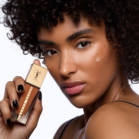 Model with YVES SAINT LAURENT Touche &Eacute;clat Le Teint Natural Glow Foundation SPF22 25ml held up to glowing skin