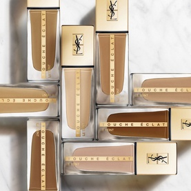 Yves Saint Laurent Touche &Eacute;clat Le Teint Foundation SPF22 25ml, multiple shades shown in tubes and boxes on marble surface