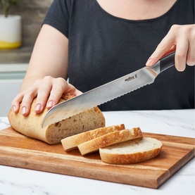 Zyliss Comfort Pro 20cm Bread Knife in stainless steel, used to slice a white loaf on a wooden chopping board