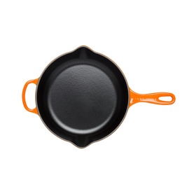 Le Creuset Signature Cast Iron Frying Pan 26cm in orange, viewed from above, showing black enamel interior and helper handle
