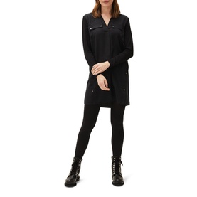 Model wearing Phase Eight Neave Button Tunic in black with long sleeves, v-neck, chest pockets, styled with black leggings and lace-up boots