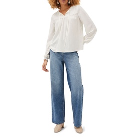 Model wearing Phase Eight Viviana Tie Neck Jersey Blouse in cream with long sleeves and frill cuffs, styled with wide-leg blue jeans
