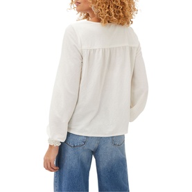 Model wearing Phase Eight Viviana Tie Neck Jersey Blouse in cream, back view, with frill cuffs and relaxed fit, styled with blue wide-leg jeans