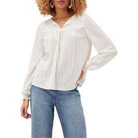 Model wearing Phase Eight Viviana Tie Neck Jersey Blouse in cream with long sleeves, necktie detail and frill cuffs, styled with blue jeans