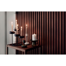 Iittala Nappula Pillar Candleholder 107mm in moss green, styled on a dark wood shelf with matching candleholders and lit taper candles