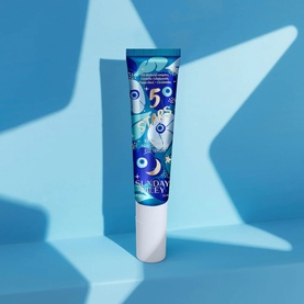 Sunday Riley Retinoid + Niacinamide Eye Serum in blue illustrated tube with evil eye and floral print design, on blue background.