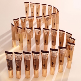 Charlotte Tilbury Beautiful Skin Foundation displayed in multiple shades, arranged in a tiered pyramid formation showing the full shade range.