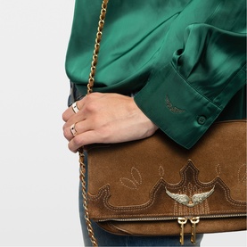 Model wearing Zadig Tink Satin Shirt in green with long sleeves, styled with a brown suede crossbody bag with gold chain strap.