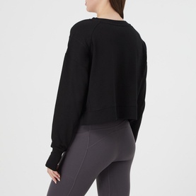 Model wearing Sweaty Betty After Class Cropped Sweatshirt in black, rear view, styled with grey marl leggings