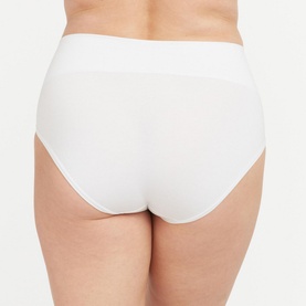 Model wearing Spanx Cotton Comfort Light Control Briefs in white, rear view showing smooth fit and double-layer waistband