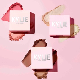 Kylie By Kylie Jenner Pressed Blush Powder compacts in three shades: pink, champagne, and brown, each shown with powder swatches on pink background