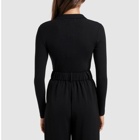 Model wearing Forever New Julia Long Sleeve Polo Top in black, fitted jersey with polo collar, paired with black wide-leg trousers. Rear view