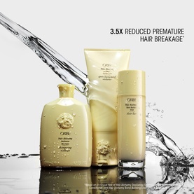 Oribe Hair Alchemy Resilience Conditioner shown in a three-piece gold haircare set with water splash, highlighting 3.5x reduced breakage claim.