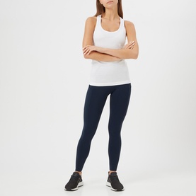 Model wearing Lululemon Swiftly Tech Racerback Tank Top in white, styled with navy leggings and black trainers, arms crossed
