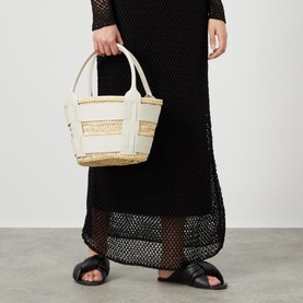 Model carrying DeMellier Miniature Santorini Basket Bag in cream, woven palm with leather trims and dual handles