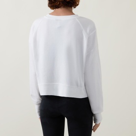 Model wearing Sweaty Betty After Class Cropped Sweatshirt in white, back view, styled with black leggings