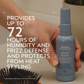 Aveda Smooth Infusion Style-Prep Smoother spray bottle held in hand, with text highlighting 72-hour humidity and frizz defence claims